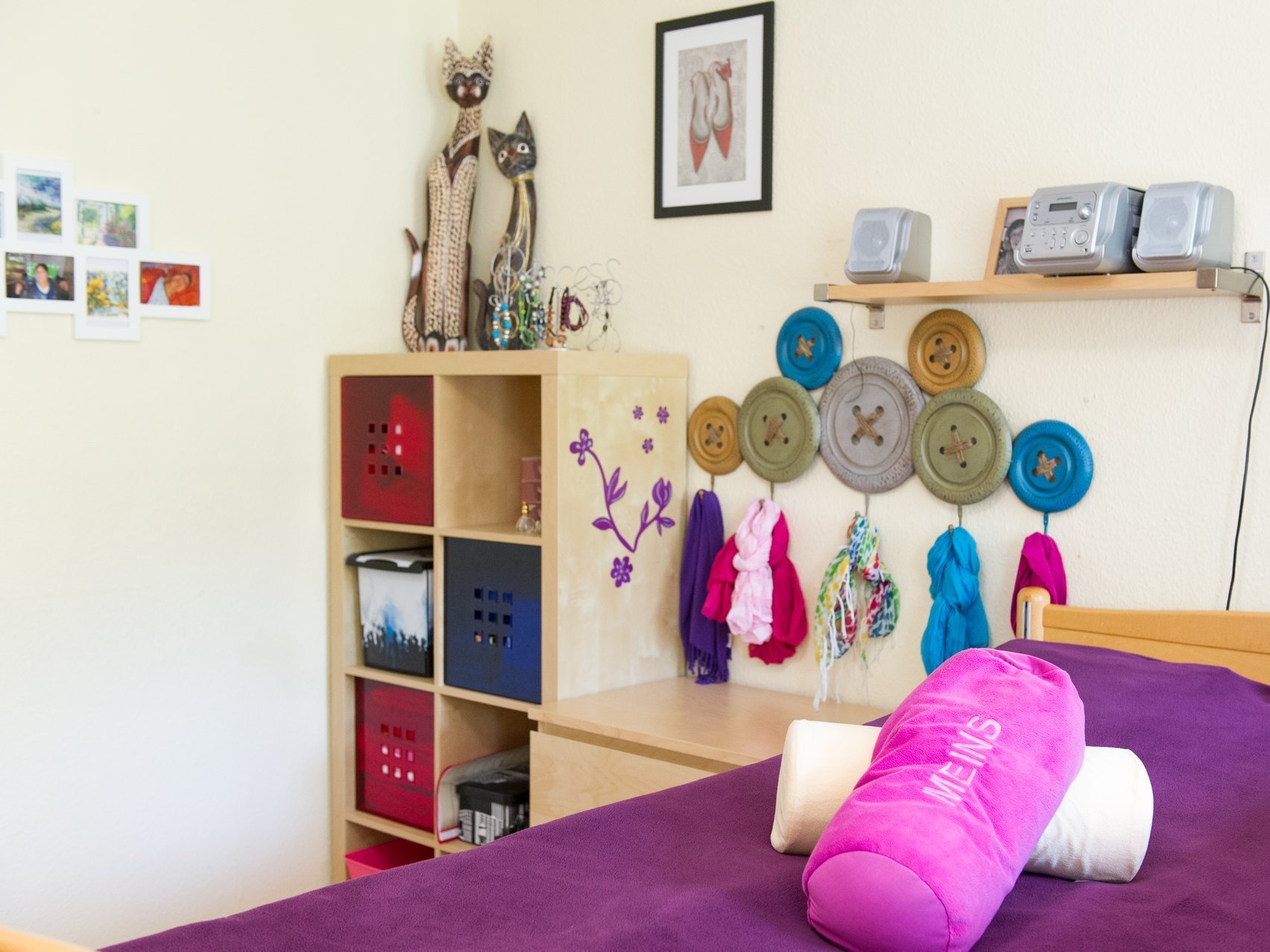 Zimmer mit Bett, vielen Bildern und Schränken - alles sehr lila und pink