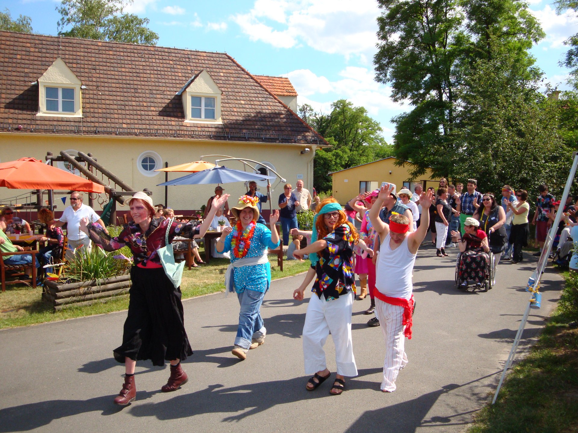 Bunte Parade auf dem Gelände: verkleidete Frauen und Männer haben Spaß bei schönstem Wetter - viele Besucher sehen zu